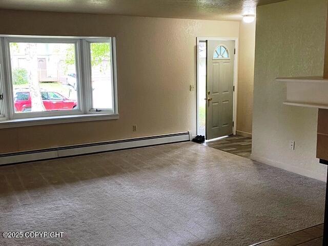3301 Pussywillow St, Anchorage, AK 99504 - entryway featuring a baseboard heating unit, carpet floors, a textured wall, and baseboards