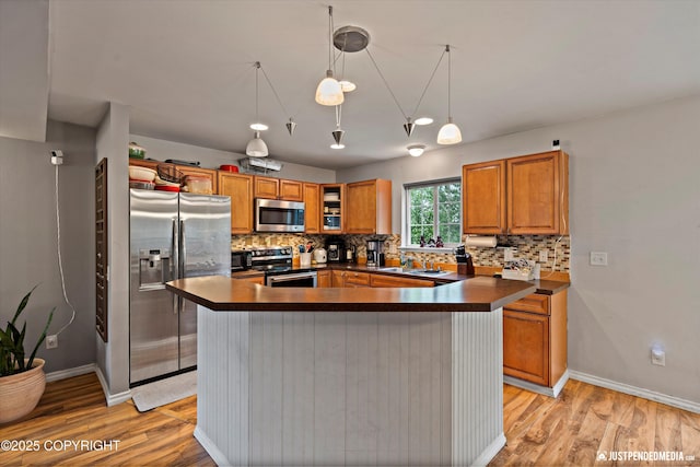 1503 N Heather Meadows Loop Unit 54, Anchorage, AK 99507 - kitchen with stainless steel appliances, dark countertops, brown cabinets, and decorative backsplash