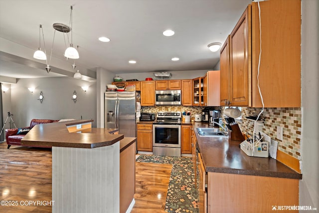 1503 N Heather Meadows Loop Unit 54, Anchorage, AK 99507 - kitchen with appliances with stainless steel finishes, a sink, dark countertops, light wood-style flooring, and brown cabinetry
