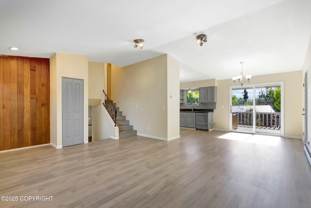 4665 Cascade Cir, Anchorage, AK 99502 - unfurnished living room with a chandelier, stairs, light wood finished floors, and baseboards