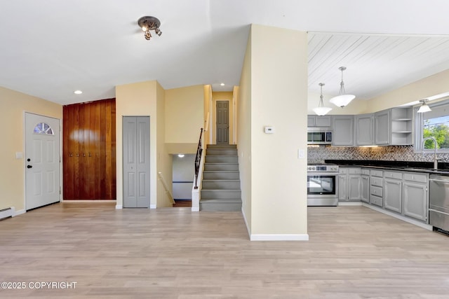 4665 Cascade Cir, Anchorage, AK 99502 - kitchen with stainless steel appliances, gray cabinets, dark countertops, light wood-style flooring, and open shelves
