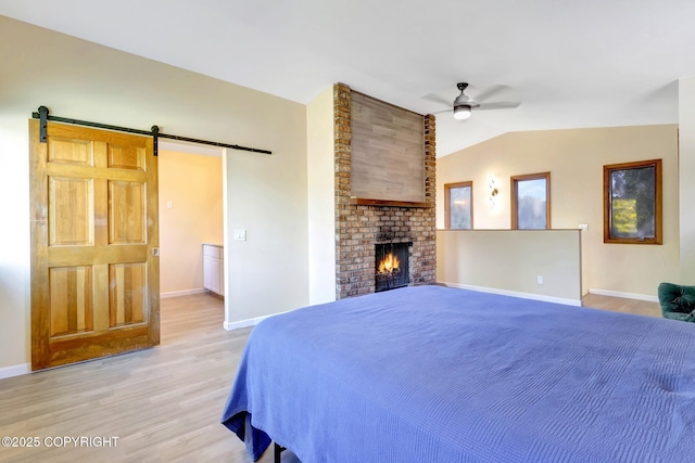 4665 Cascade Cir, Anchorage, AK 99502 - bedroom featuring light wood-type flooring, baseboards, vaulted ceiling, and a barn door