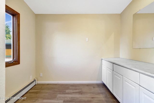 4665 Cascade Cir, Anchorage, AK 99502 - kitchen featuring a baseboard radiator, light wood-type flooring, white cabinetry, and light countertops