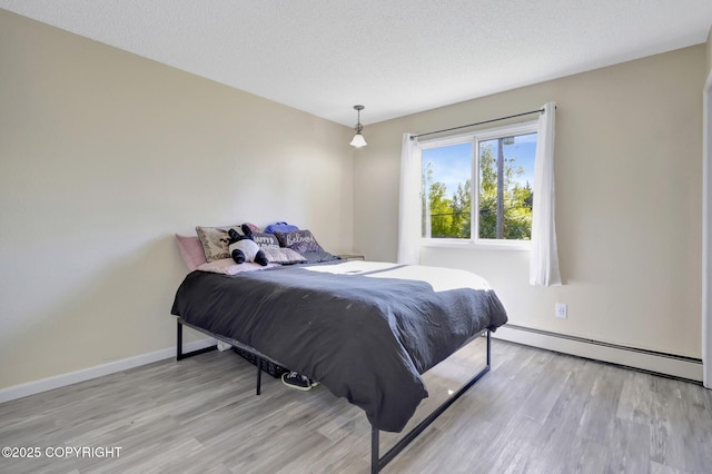 4665 Cascade Cir, Anchorage, AK 99502 - bedroom featuring baseboard heating, wood finished floors, baseboards, and a textured ceiling
