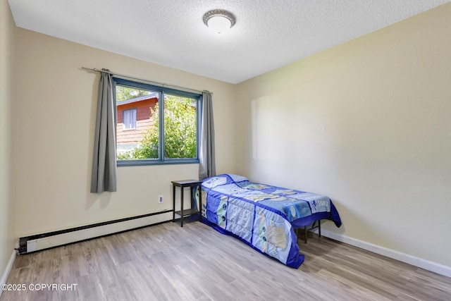4665 Cascade Cir, Anchorage, AK 99502 - bedroom with a baseboard heating unit, wood finished floors, baseboards, and a textured ceiling