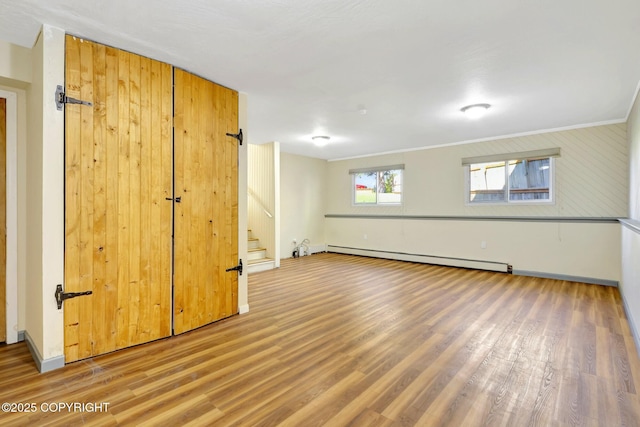 4665 Cascade Cir, Anchorage, AK 99502 - below grade area featuring baseboard heating, wood finished floors, stairs, and baseboards