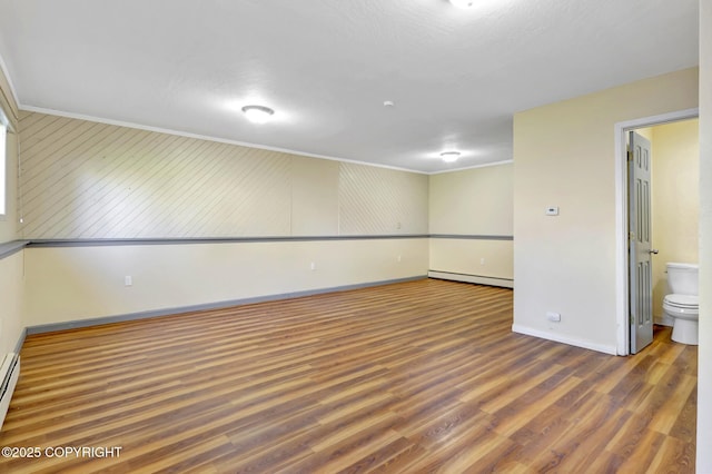4665 Cascade Cir, Anchorage, AK 99502 - empty room featuring a baseboard radiator, crown molding, baseboards, and wood finished floors