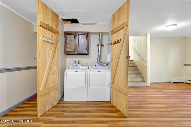 4665 Cascade Cir, Anchorage, AK 99502 - laundry room featuring separate washer and dryer, light wood-type flooring, cabinet space, and crown molding