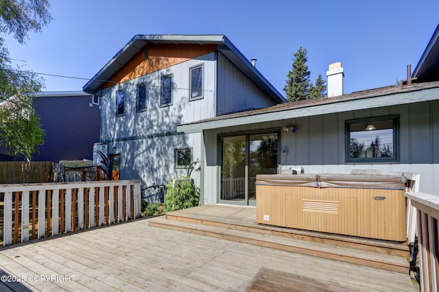 4665 Cascade Cir, Anchorage, AK 99502 - back of property featuring a hot tub, a wooden deck, and a chimney