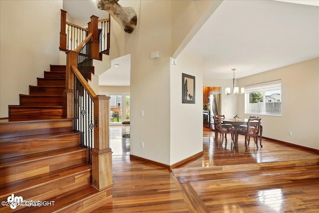10410 Constitution St, Anchorage, AK 99515 - foyer entrance with a chandelier, wood-type flooring, baseboards, and stairway