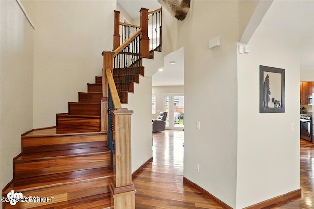 10410 Constitution St, Anchorage, AK 99515 - staircase with wood finished floors, a high ceiling, and baseboards