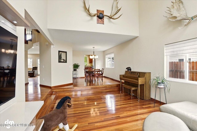 10410 Constitution St, Anchorage, AK 99515 - living room with a chandelier, light wood-type flooring, a high ceiling, and baseboards