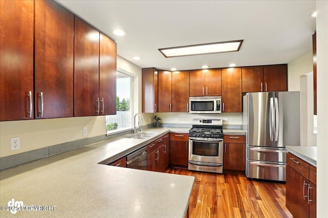 10410 Constitution St, Anchorage, AK 99515 - kitchen featuring appliances with stainless steel finishes, a sink, light countertops, dark wood-type flooring, and recessed lighting