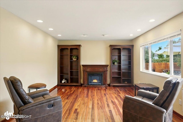 10410 Constitution St, Anchorage, AK 99515 - living area with a warm lit fireplace, recessed lighting, wood finished floors, and baseboards