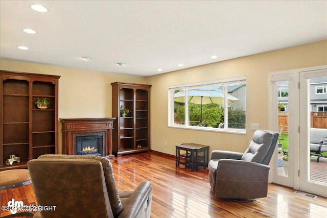 10410 Constitution St, Anchorage, AK 99515 - living area with a lit fireplace, hardwood / wood-style flooring, recessed lighting, and baseboards
