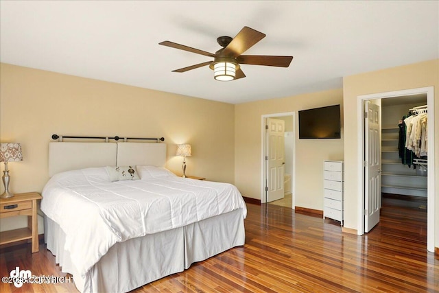 10410 Constitution St, Anchorage, AK 99515 - bedroom with wood finished floors, a walk in closet, a ceiling fan, a closet, and baseboards