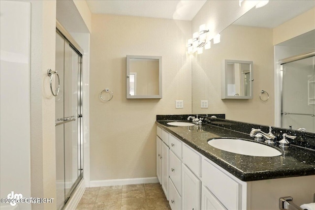 10410 Constitution St, Anchorage, AK 99515 - bathroom with a shower stall, double vanity, baseboards, and tile patterned floors