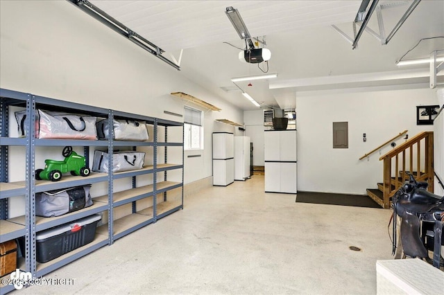 10410 Constitution St, Anchorage, AK 99515 - garage featuring white fridge, electric panel, freestanding refrigerator, and a garage door opener