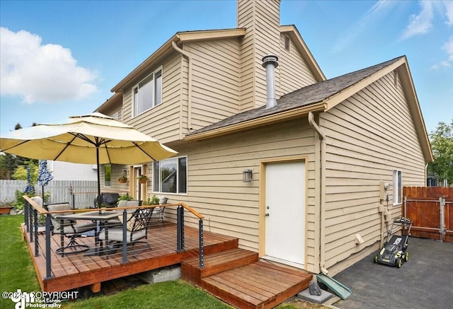 10410 Constitution St, Anchorage, AK 99515 - back of property with a wooden deck, outdoor dining space, and a chimney