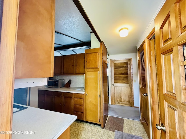 1310 Madsen Ave, Kodiak, AK 99615 - kitchen with light countertops, stainless steel microwave, and brown cabinetry