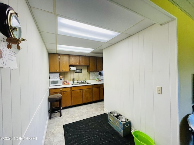 1310 Madsen Ave, Kodiak, AK 99615 - kitchen with white microwave, brown cabinets, a sink, and light countertops