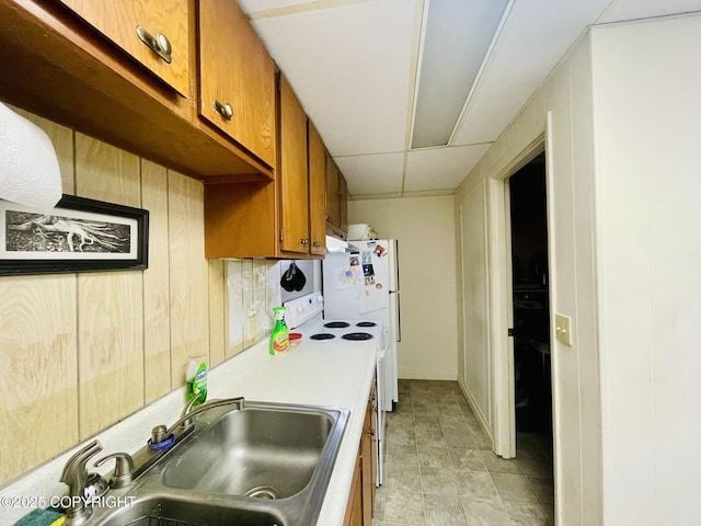 1310 Madsen Ave, Kodiak, AK 99615 - kitchen with brown cabinetry, a sink, light countertops, freestanding refrigerator, and wood walls