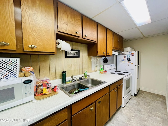1310 Madsen Ave, Kodiak, AK 99615 - kitchen with white appliances, a sink, light countertops, under cabinet range hood, and brown cabinets