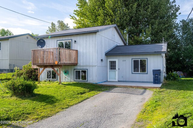 639 E Beaver Ave, Palmer, AK 99645 - view of front of property featuring a front lawn, roof with shingles, a balcony, and asphalt driveway