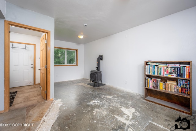 639 E Beaver Ave, Palmer, AK 99645 - unfurnished living room featuring a wood stove and concrete floors