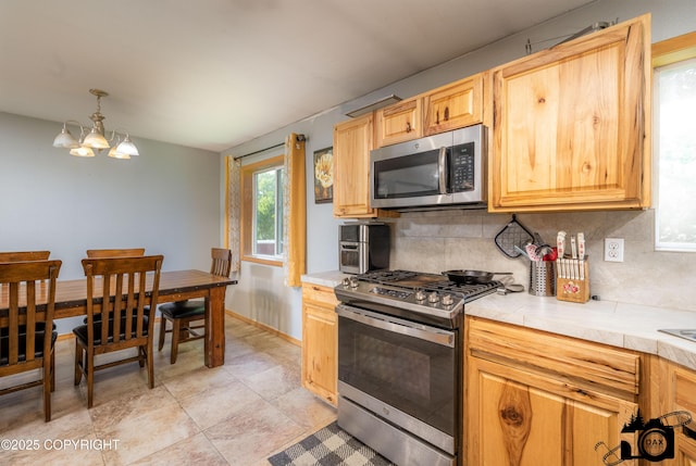 639 E Beaver Ave, Palmer, AK 99645 - kitchen featuring stainless steel appliances, a chandelier, decorative backsplash, hanging light fixtures, and baseboards