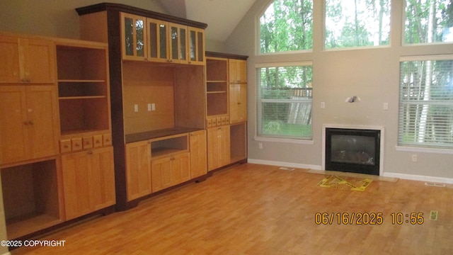 2024 Oxbow Cir, Anchorage, AK 99516 - unfurnished living room featuring light wood-style flooring, vaulted ceiling, and a fireplace with flush hearth