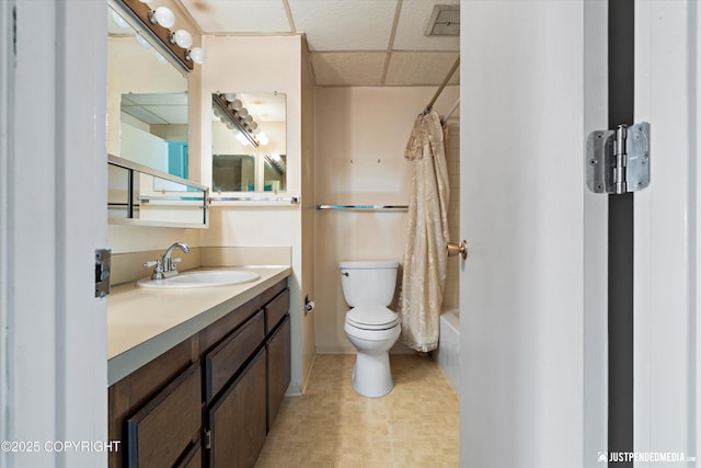 836 M St # 215, Anchorage, AK 99501 - bathroom featuring toilet, vanity, a drop ceiling, and shower / bathtub combination with curtain