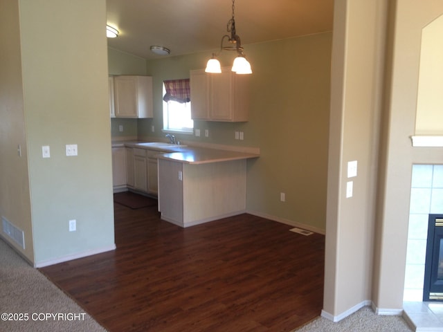 6334 Rose Hip Cir, Anchorage, AK 99507 - kitchen with dark wood-style floors, light countertops, hanging light fixtures, and a peninsula