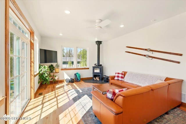 7350 E Narnia Cir, Palmer, AK 99645 - living room with plenty of natural light, a wood stove, wood finished floors, a ceiling fan, and recessed lighting