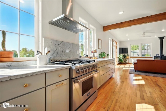 7350 E Narnia Cir, Palmer, AK 99645 - kitchen with high end stove, wall chimney exhaust hood, beamed ceiling, light wood-type flooring, and backsplash
