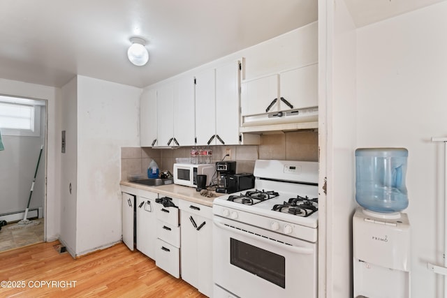 241 N Flower St, Anchorage, AK 99508 - kitchen with white appliances, under cabinet range hood, baseboard heating, decorative backsplash, and light wood-style flooring