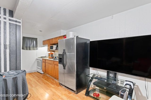 241 N Flower St, Anchorage, AK 99508 - kitchen featuring white appliances, light wood finished floors, brown cabinetry, and light countertops