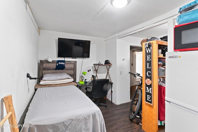 241 N Flower St, Anchorage, AK 99508 - bedroom featuring wood finished floors and freestanding refrigerator