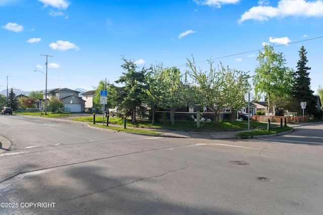 241 N Flower St, Anchorage, AK 99508 - view of asphalt road with traffic signs, curbs, a residential view, and sidewalks