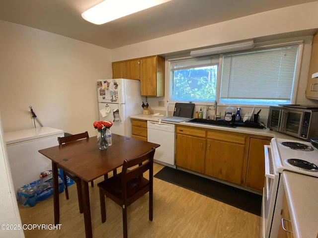 4312 Penguin St, Anchorage, AK 99503 - kitchen featuring white appliances, a sink, light wood finished floors, and light countertops