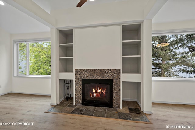 905 Wild Rose Ct # 905, Anchorage, AK 99518 - unfurnished living room with a fireplace, a ceiling fan, baseboards, and built in features