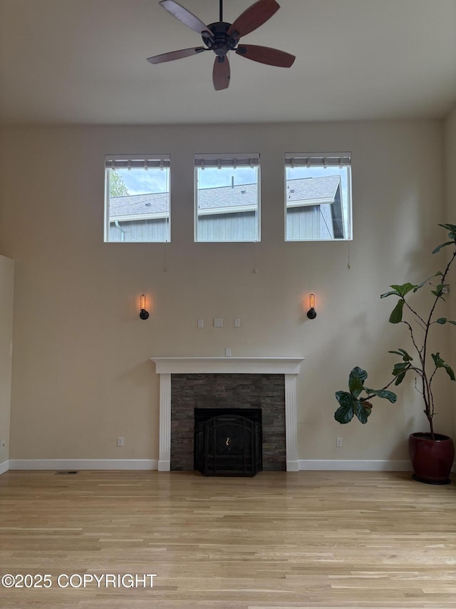 13125 W Curry Ridge Cir, Eagle River, AK 99577 - unfurnished living room featuring wood finished floors, baseboards, ceiling fan, a high ceiling, and a fireplace