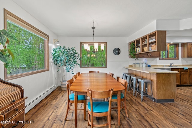 45035 Ptarmigan Pl, Soldotna, AK 99669 - dining area with a baseboard heating unit, dark wood-style flooring, plenty of natural light, and a chandelier
