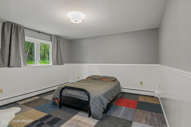 45035 Ptarmigan Pl, Soldotna, AK 99669 - bedroom with a baseboard radiator, a wainscoted wall, and a textured ceiling