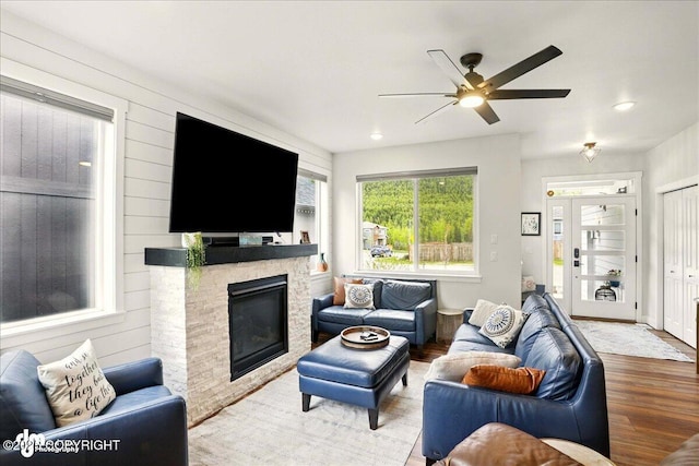 8727 Turlock Dr, Eagle River, AK 99577 - living area featuring wood finished floors, a ceiling fan, a stone fireplace, and recessed lighting