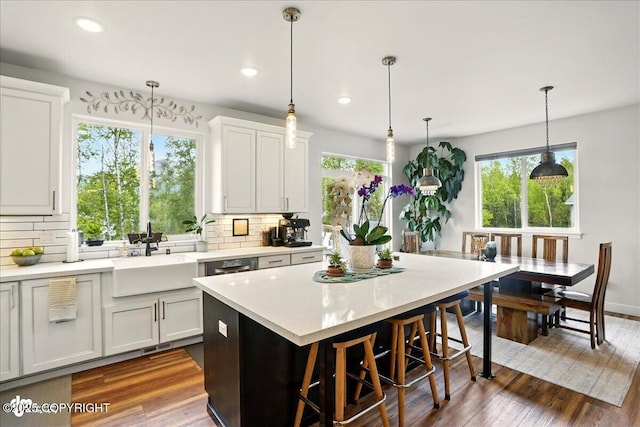 8727 Turlock Dr, Eagle River, AK 99577 - kitchen with a sink, tasteful backsplash, light countertops, hanging light fixtures, and a kitchen breakfast bar