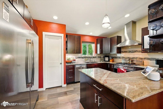 3872 N Charley Dr, Wasilla, AK 99654 - kitchen with appliances with stainless steel finishes, wall chimney exhaust hood, a sink, tasteful backsplash, and recessed lighting