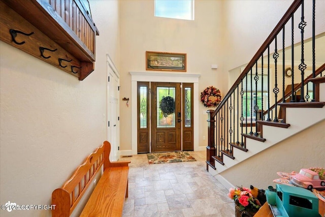 2034 E Sage Rd, Wasilla, AK 99654 - entryway featuring stone finish flooring, a high ceiling, baseboards, and stairway