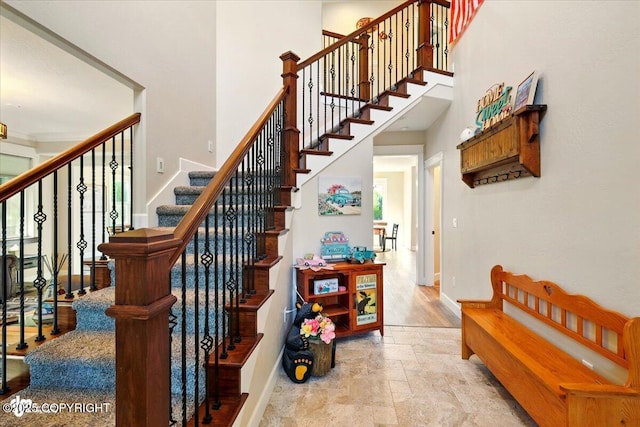 2034 E Sage Rd, Wasilla, AK 99654 - staircase featuring baseboards, stone finish flooring, and a towering ceiling