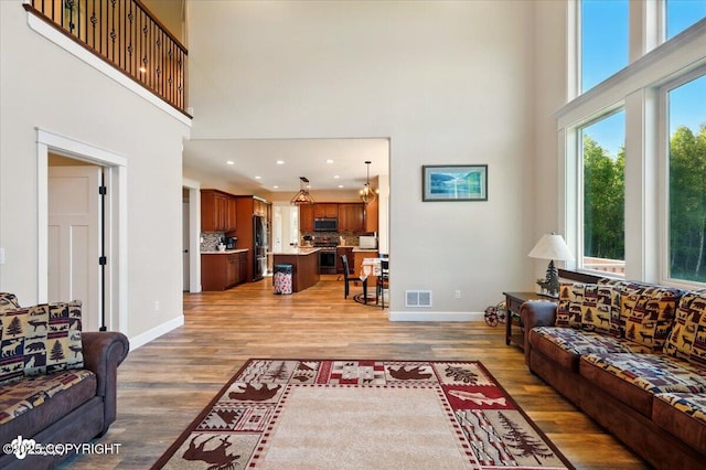 2034 E Sage Rd, Wasilla, AK 99654 - living room with a towering ceiling, baseboards, light wood finished floors, and recessed lighting